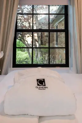 a pillow on a bed in front of a window at The Glenerin Inn in Mississauga