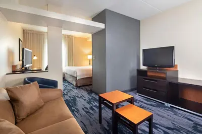 a hotel room with a couch and a tv and a bed at Fairfield Inn & Suites by Marriott Toronto Mississauga in Mississauga