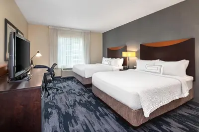 a hotel room with two beds and a flat screen tv at Fairfield Inn & Suites by Marriott Toronto Mississauga in Mississauga
