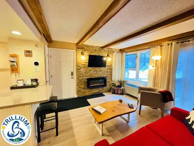 a living room with a red couch and a table at Rustic Mountainside Chalet in Blue Mountains