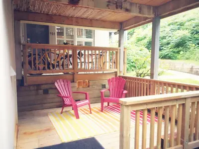 two pink chairs sitting on a wooden deck at Rustic Mountainside Chalet in Blue Mountains