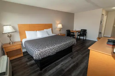 a hotel room with a bed and a table and chairs at Borden Inn and Suites in Angus