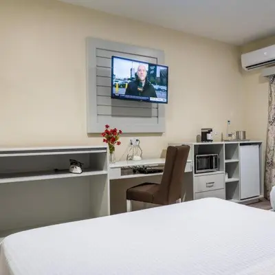 a bedroom with a bed and a tv on the wall at Leelas Villa Inn Flesherton in Flesherton