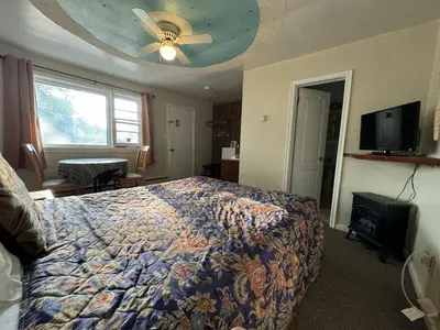 a bedroom with a bed and a ceiling fan at Holiday Motel in Orillia