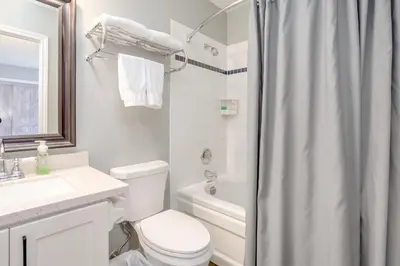 a white bathroom with a toilet and a shower at Blue Mountain Studio Loft at North Creek Resort in Blue Mountains