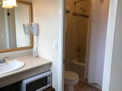 a bathroom with a sink and a toilet and a shower at Cardinal Court Motel in Saint Thomas