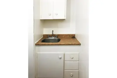 a kitchen with a sink and white cabinets at Bayside Motel Trenton in Trenton