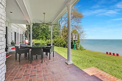 a patio with a table and chairs and the ocean at Somerset - A Private Retreat in Niagara on the Lake