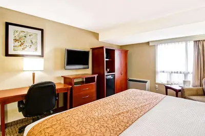 a hotel room with a bed and a desk and a television at Quality Inn in Kitchener