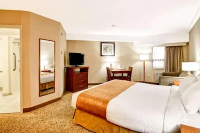 a hotel room with a large bed and a bathroom at Quality Inn in Kitchener
