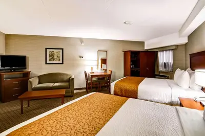 a hotel room with two beds and a desk at Quality Inn in Kitchener