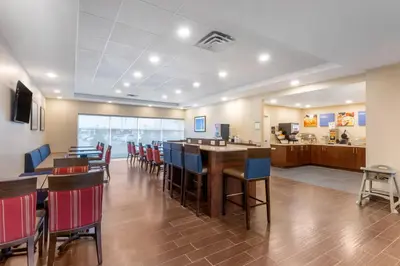 a restaurant with chairs and a bar in a room at Comfort Inn & Suites in Bowmanville