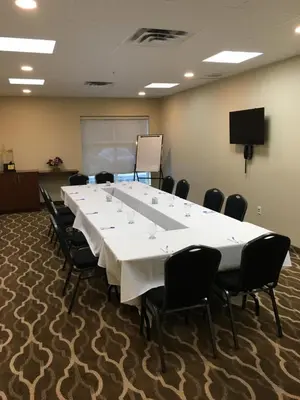 a conference room with a large white table and chairs at Comfort Inn & Suites in Bowmanville