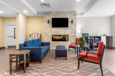 a lobby with a couch and chairs and a fireplace at Comfort Inn & Suites in Bowmanville