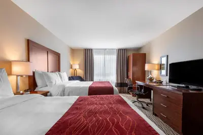 a hotel room with two beds and a flat screen tv at Comfort Inn & Suites in Bowmanville