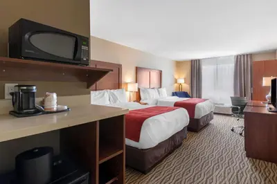 a hotel room with two beds and a flat screen tv at Comfort Inn & Suites in Bowmanville