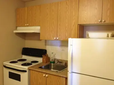 a kitchen with a white refrigerator and a sink at Lotus Motel in Cobourg