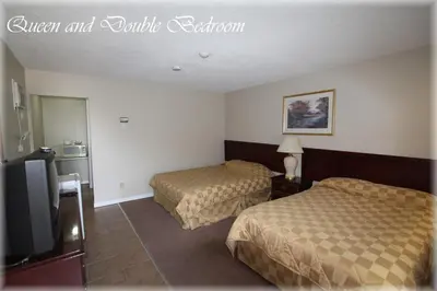 a hotel room with two beds and a flat screen tv at Lotus Motel in Cobourg