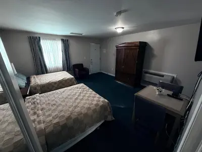 a hotel room with two beds and a table at Guest Inn Motel in Trenton