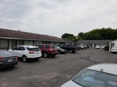 a group of cars parked in a parking lot at Guest Inn Motel in Trenton