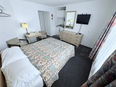 a hotel room with a bed and a television at Guest Inn Motel in Trenton