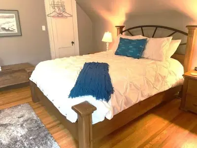 a bedroom with a bed with a blue blanket on it at Cottage on Caledonia Bed & Breakfast in Stratford