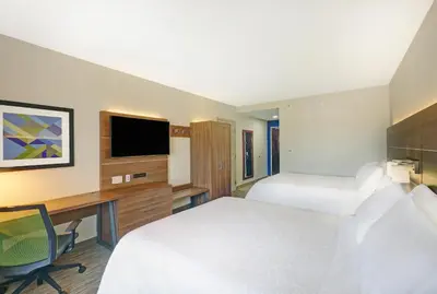 a hotel room with two beds and a desk and a tv at Holiday Inn Express & Suites - Woodstock, ON CANADA in Woodstock
