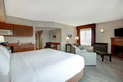 a hotel room with a bed and a living room at Days Inn & Suites by Wyndham Collingwood in Collingwood