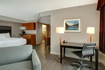 a hotel room with a bed and a desk and a bed at Days Inn & Suites by Wyndham Collingwood in Collingwood