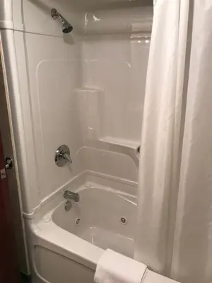 a white bath tub with a shower curtain in a bathroom at Country Inn Listowel in Listowel