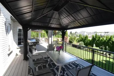 a patio with a table and chairs on a deck at Graystone Bed & Breakfast in Niagara on the Lake