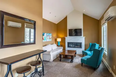 a living room with a couch and a fireplace at The Inn at Cobble Beach in Kemble