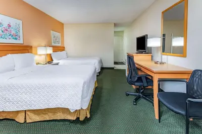 a hotel room with two beds and a desk and a computer at Travelodge by Wyndham Bracebridge in Bracebridge
