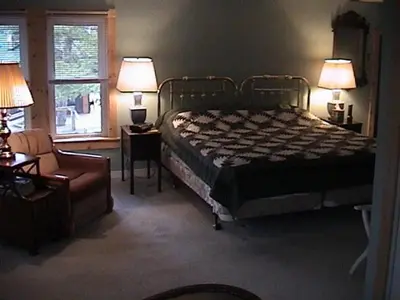 a bedroom with a bed and a couch and a window at Sunny Rock Bed & Breakfast in Minden