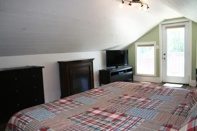 a bedroom with a large bed and a tv at Hadovka Lakeside Inn in Wellington