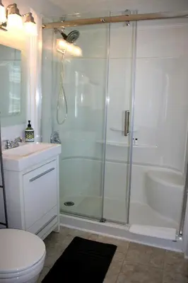 a bathroom with a shower and a toilet and a sink at Hadovka Lakeside Inn in Wellington