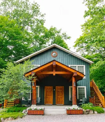 a green house with a gambrel roof at Heather Lodge in Minden