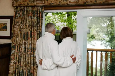 a man and woman standing in front of a window at Heather Lodge in Minden