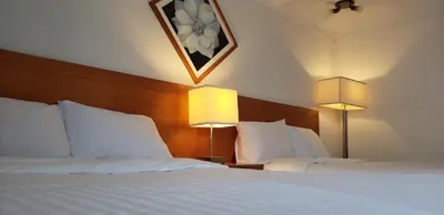 a hotel room with two beds and two lamps at Niagara Inn in Niagara Falls