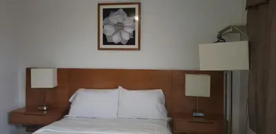 a bed with two lamps and a picture on the wall at Niagara Inn in Niagara Falls