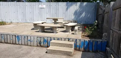 a picnic table and benches in front of a fence at Niagara Inn in Niagara Falls