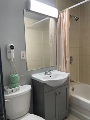 a bathroom with a sink and a toilet and a mirror at Liberty Inn in Bowmanville