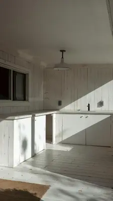 a white kitchen with a large white counter top at The Lakeside Prince Edward County in Wellington