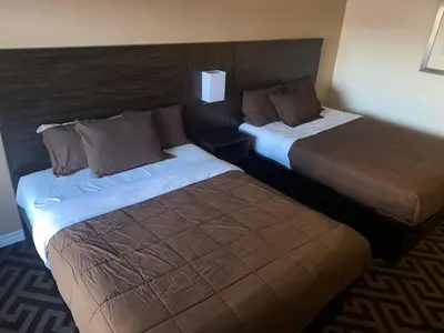 two beds sitting next to each other in a hotel room at Falls Lodge by the Falls (Formerly Knights Inn) in Niagara Falls