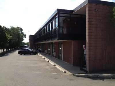a car parked in a parking lot next to a building at Mississauga Gate Inn in Mississauga