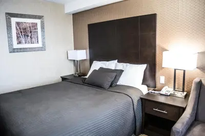 a hotel room with a bed and a chair at Mississauga Gate Inn in Mississauga