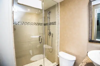 a bathroom with a shower with a toilet and a sink at Mississauga Gate Inn in Mississauga