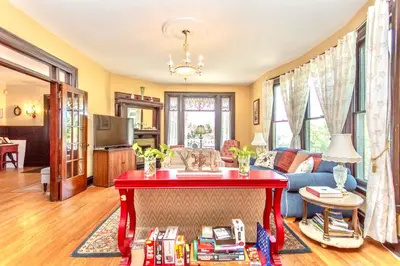 a living room with a red table with books on it at Redwood Bed and Breakfast in Niagara Falls