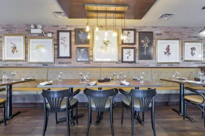 a dining room with tables and chairs and pictures on the wall at Northumberland Heights Wellness Retreat & Spa in Cobourg