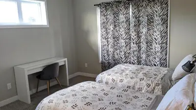 a bedroom with a bed and a desk and a window at Boardwalk Homes - Executive Guest Rooms & Townhomes in Kitchener